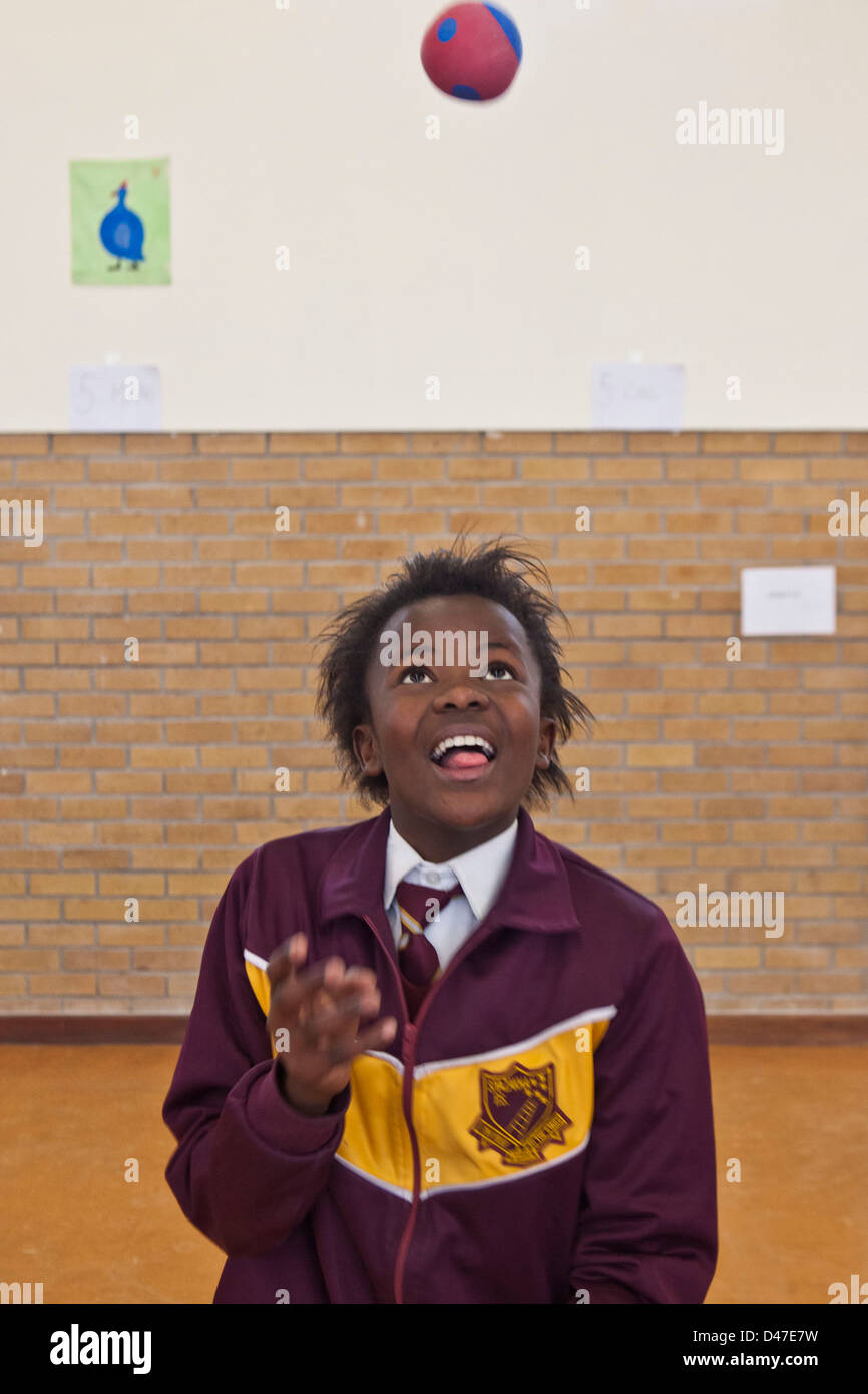 African school girl juggling balls as part of a circus class in hall of