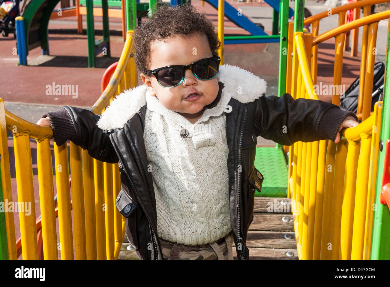 Mixed race toddler baby crossing a bridge with yellow railings, front
