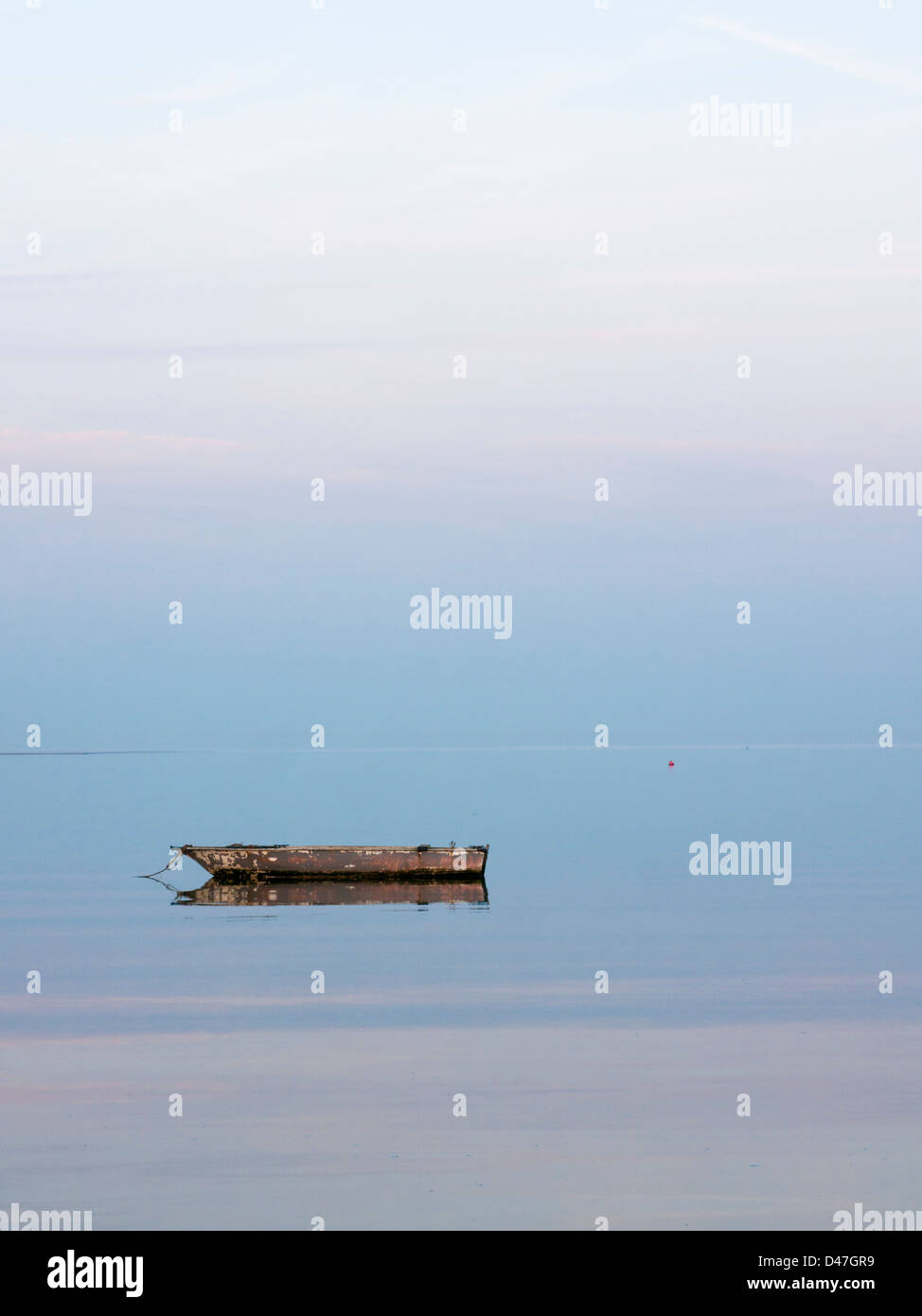 Small boat moored on calm waters Stock Photo