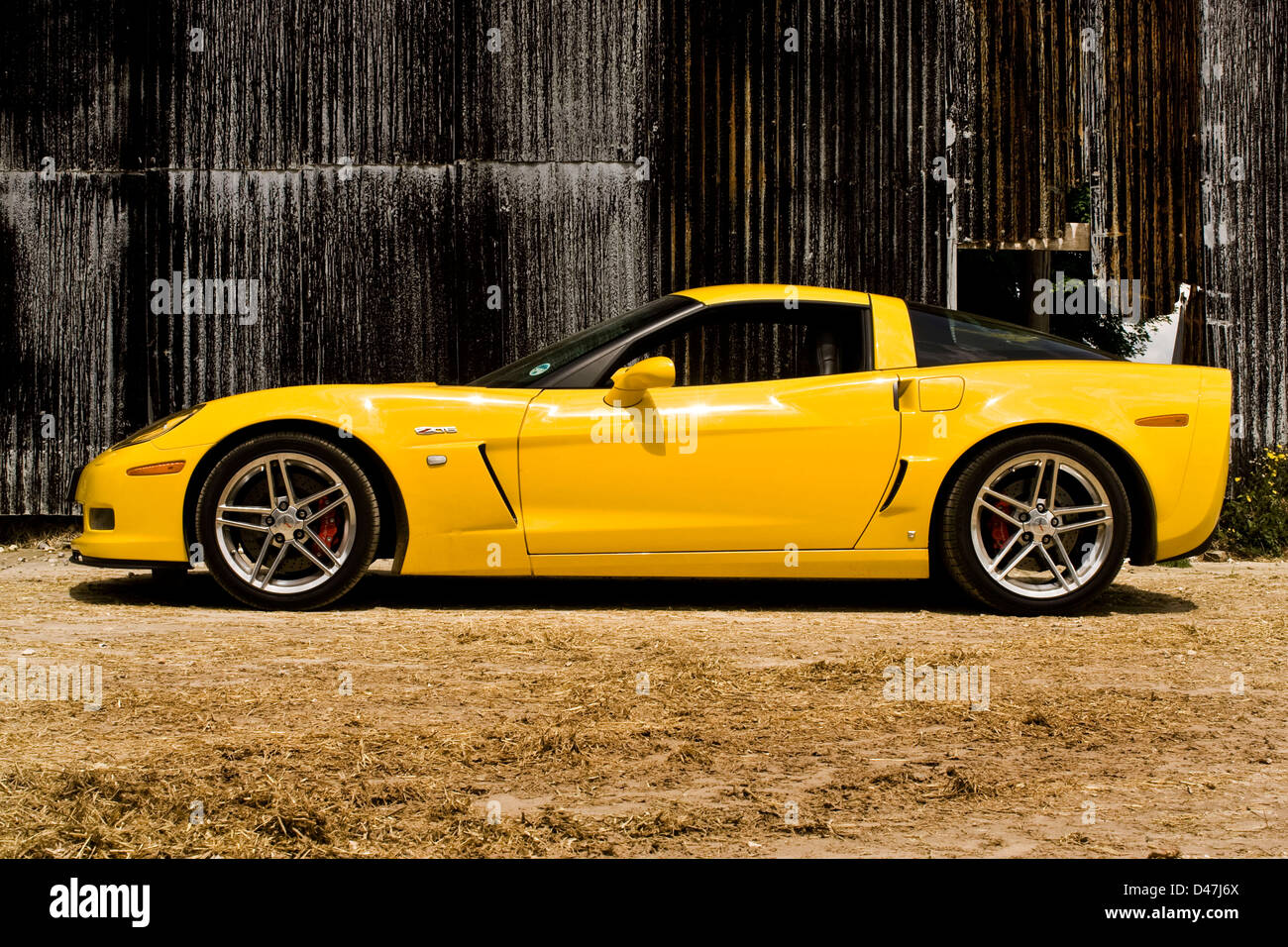 Yellow Chevrolet Corvette Z 06 with corrugated building Stock Photo