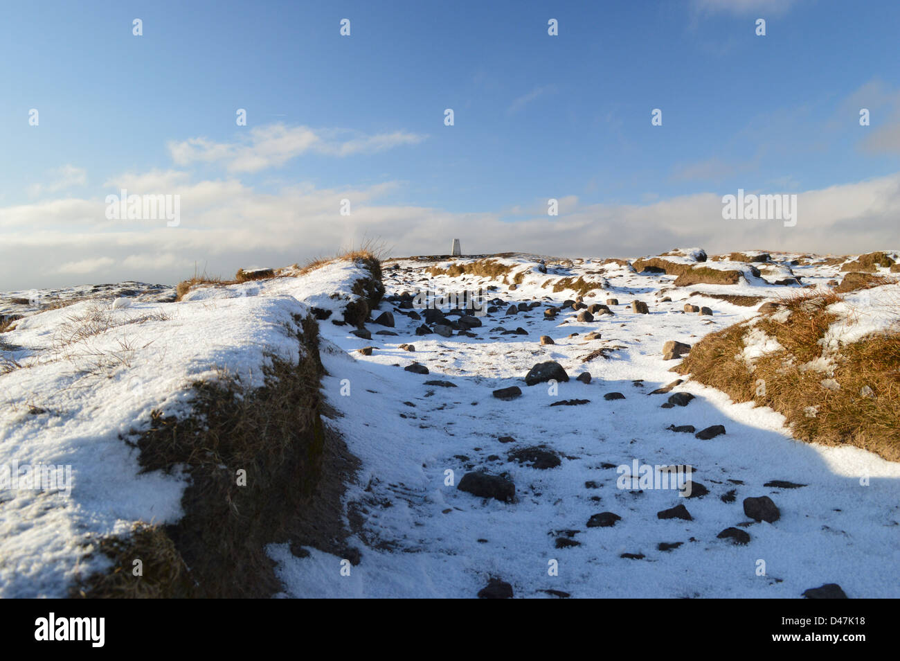 Footpath Through the Snow & Peat Hags Leading to The Summit Trig Point of Pendle Hill in Snow on a Sunny Winters Day Stock Photo