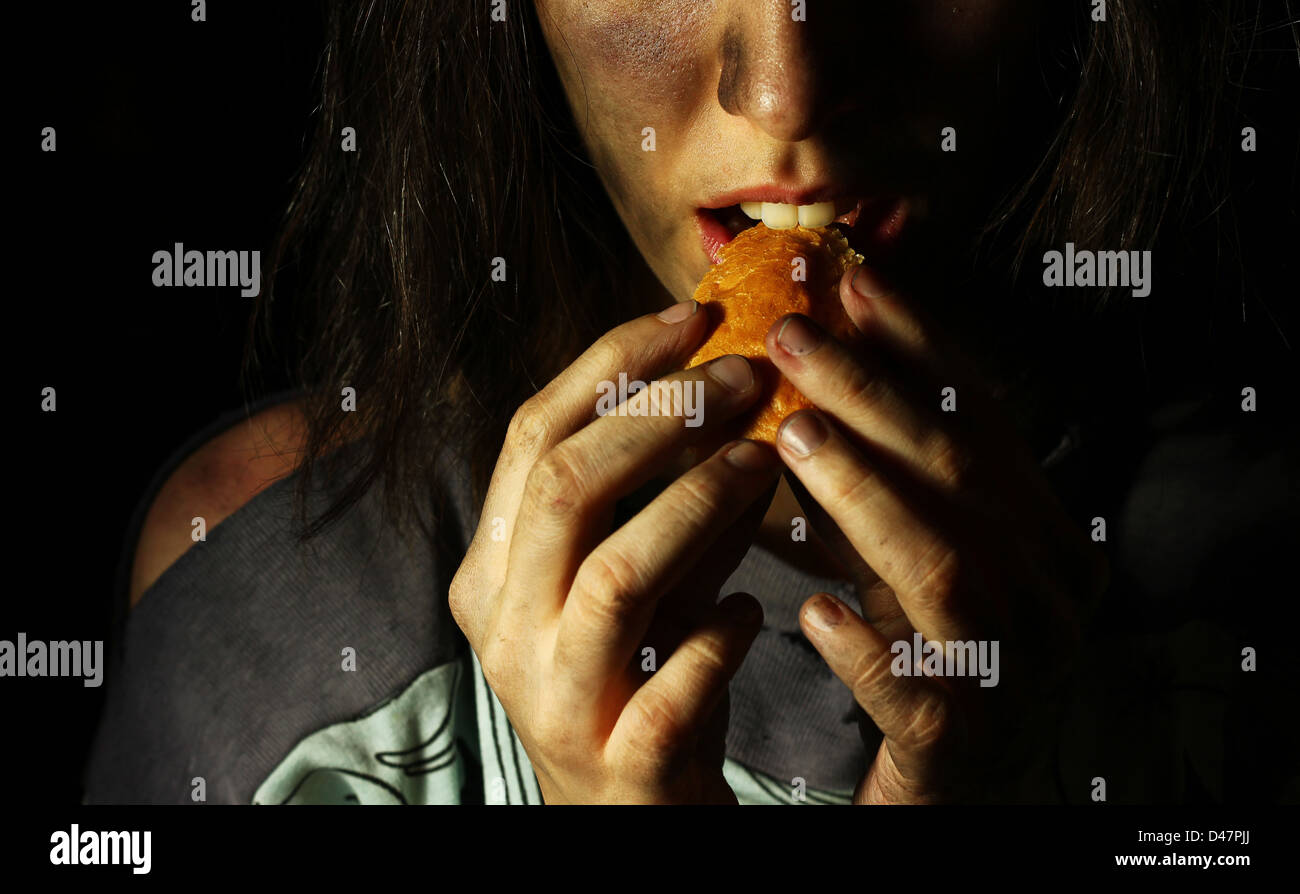 Poor dirty girl eating a piece of bread Stock Photo
