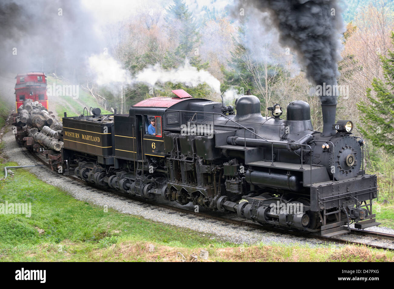 Steam engine train hauling logs rounding curve. Stock Photo