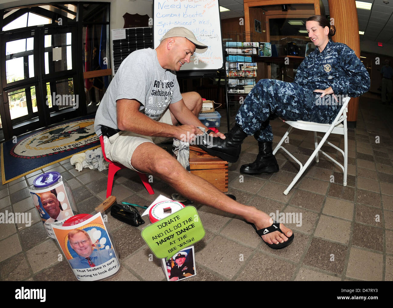 The XO of Naval Construction Battalion Center shines the boots of a