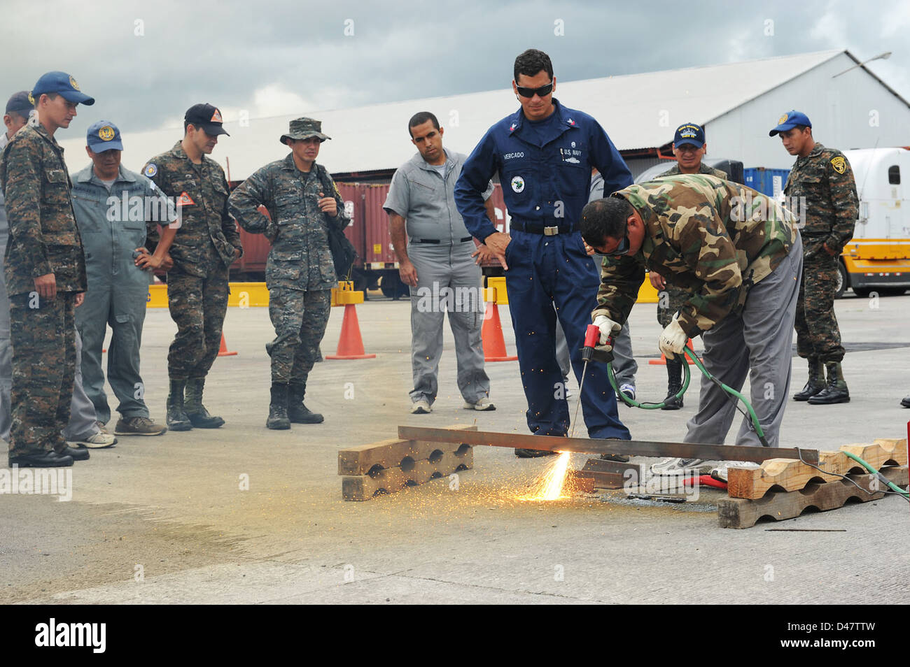 A U.S. Navy diver observes a Guatemalan diver cutting metal. Stock Photo