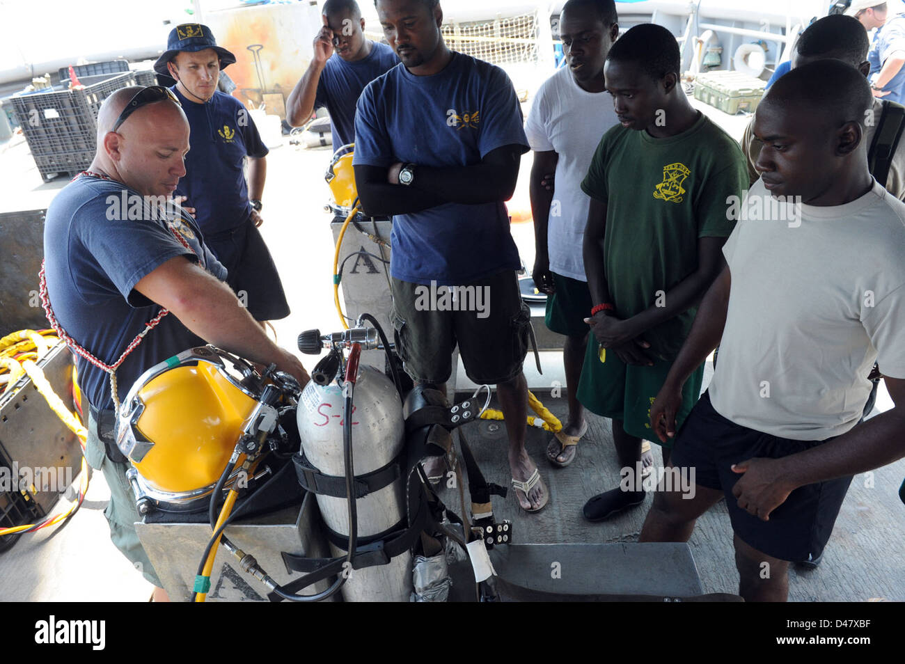 A U.S. navy diver explains the functions of a KM 37 diving helmet to Bahamian divers. Stock Photo