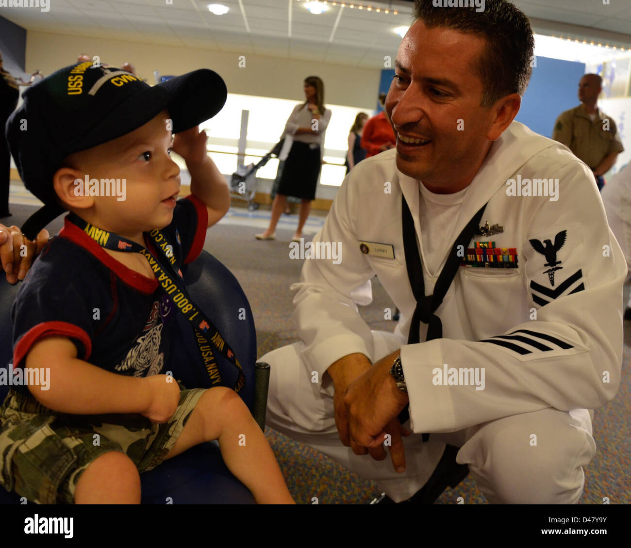 A Sailor gives a boy a Navy ball cap at the Children's Hospital in Boston as part of Caps for Kids during Boston Navy Week. Stock Photo