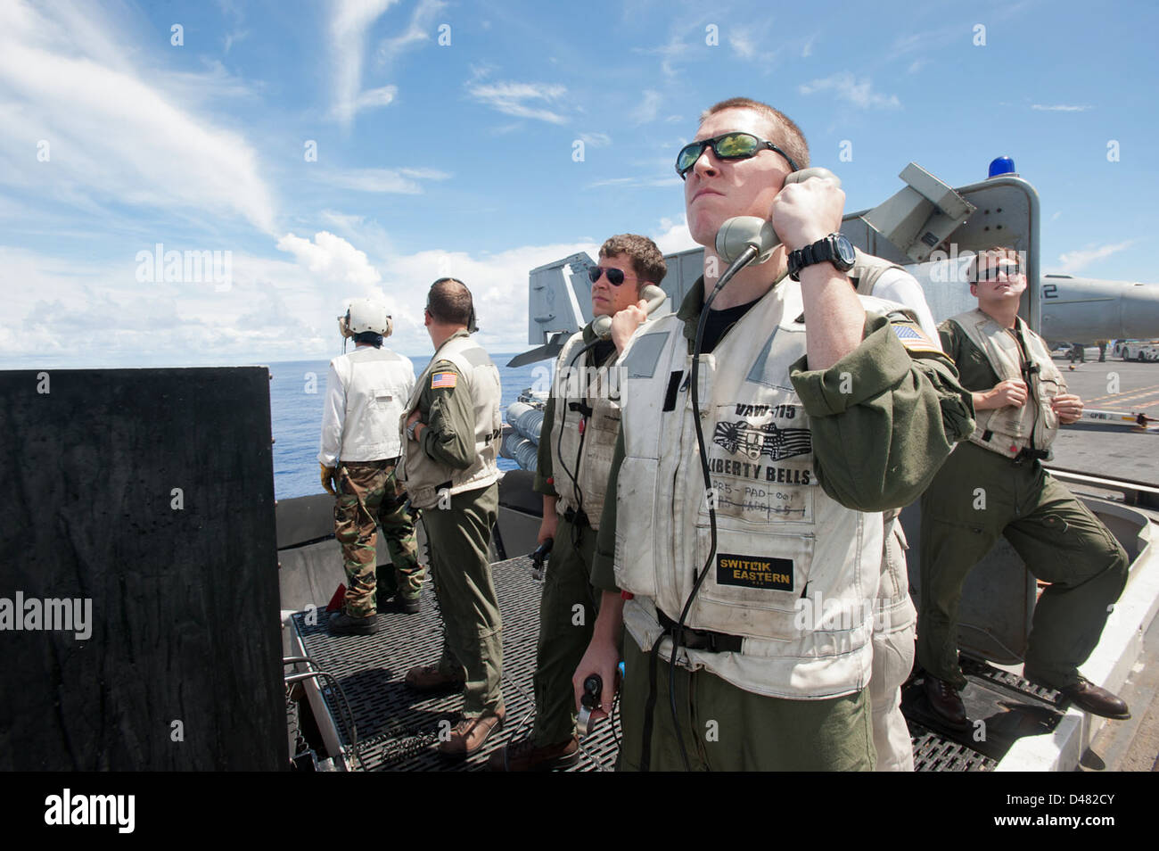 Landing signal officers stand by to help guide approaching aircraft