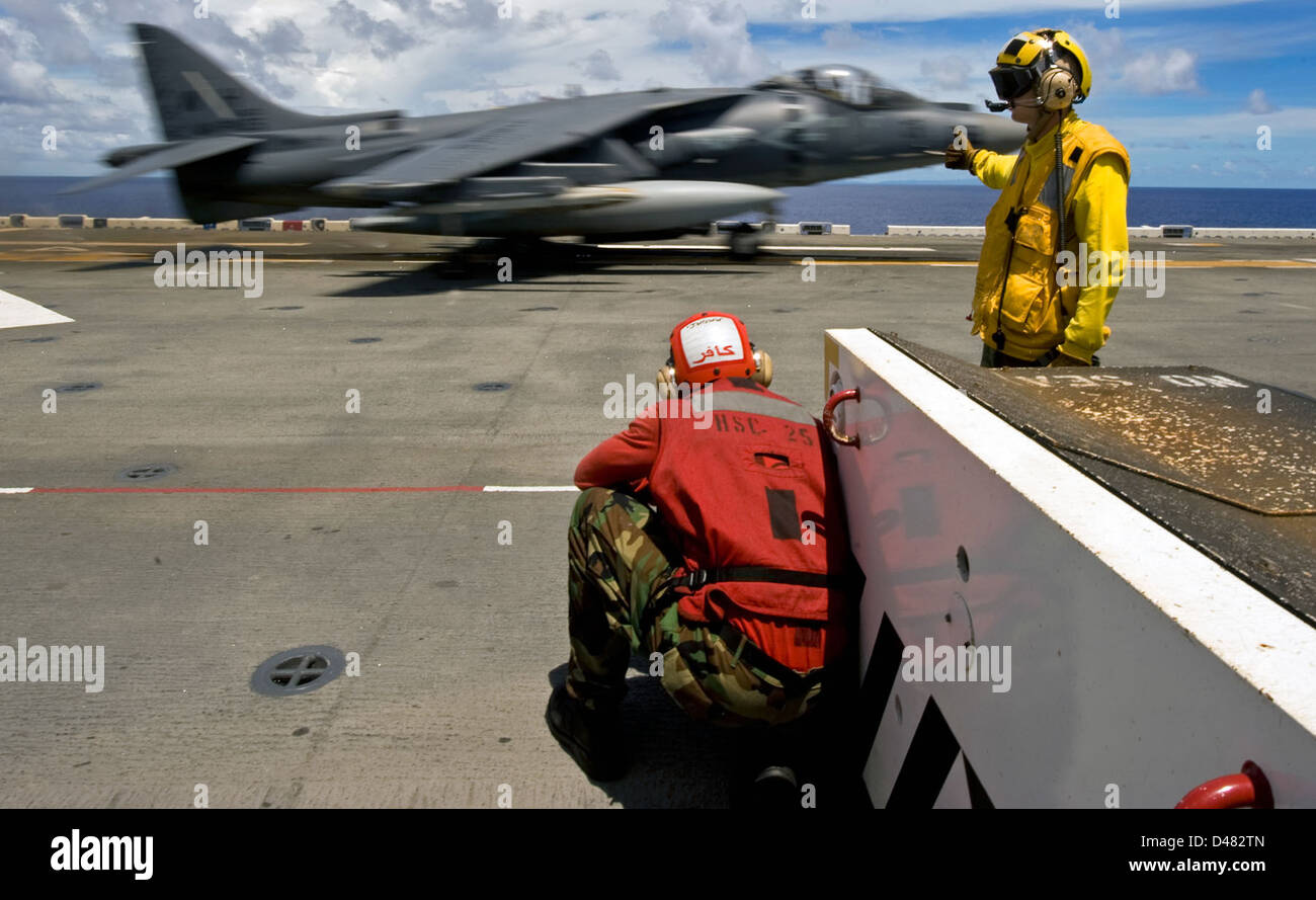 A Sailor directs the launch of an Harrier jet. Stock Photo
