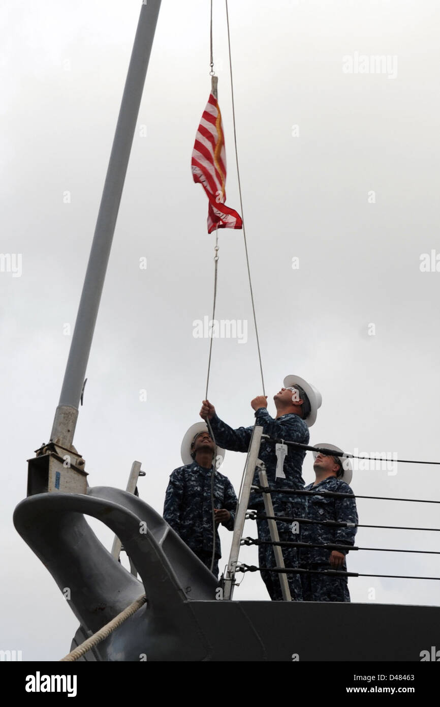 Sailors rase the Navy Jack. Stock Photo