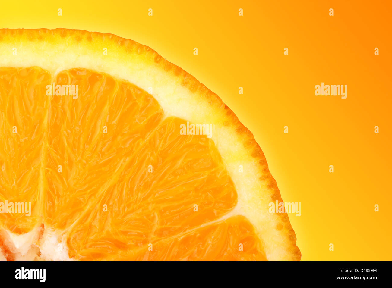 orange slice in front of yellow orange background Stock Photo