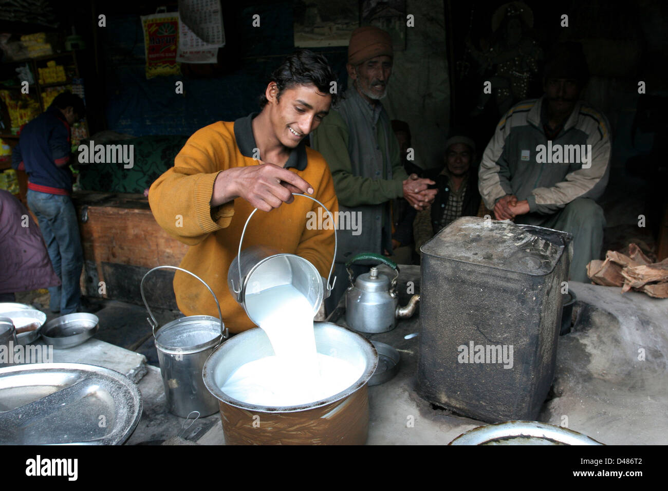 Garhwali man pours milk in a road side restaurant in Chopta. Stock Photo