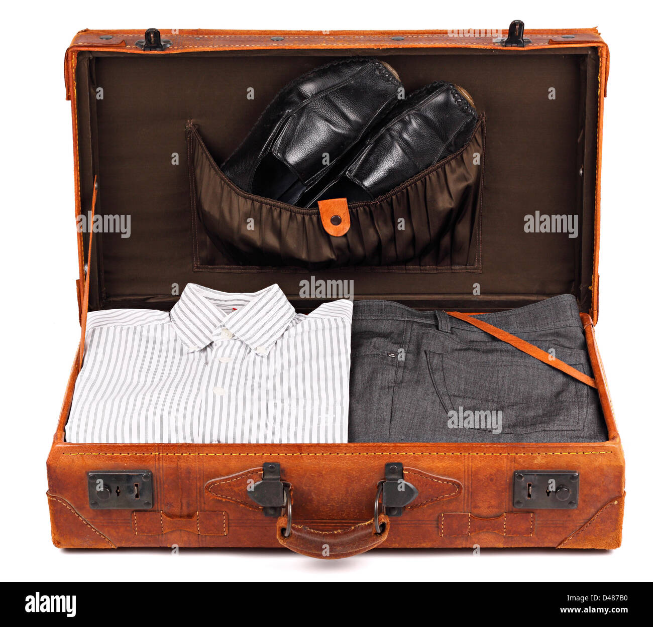 An old leather suitcase with business clothes on white background Stock Photo