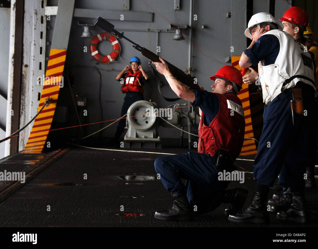A Sailor aboard a U.S. Navy vessel prepares to shoot a line to another ...
