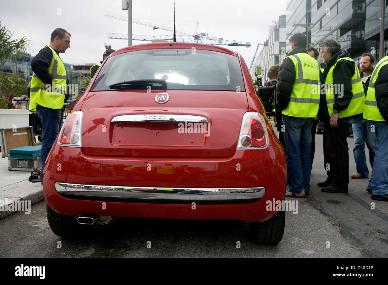 Red Fiat 500 CC with a film rig attached and crew preparing the vehicle Stock Photo