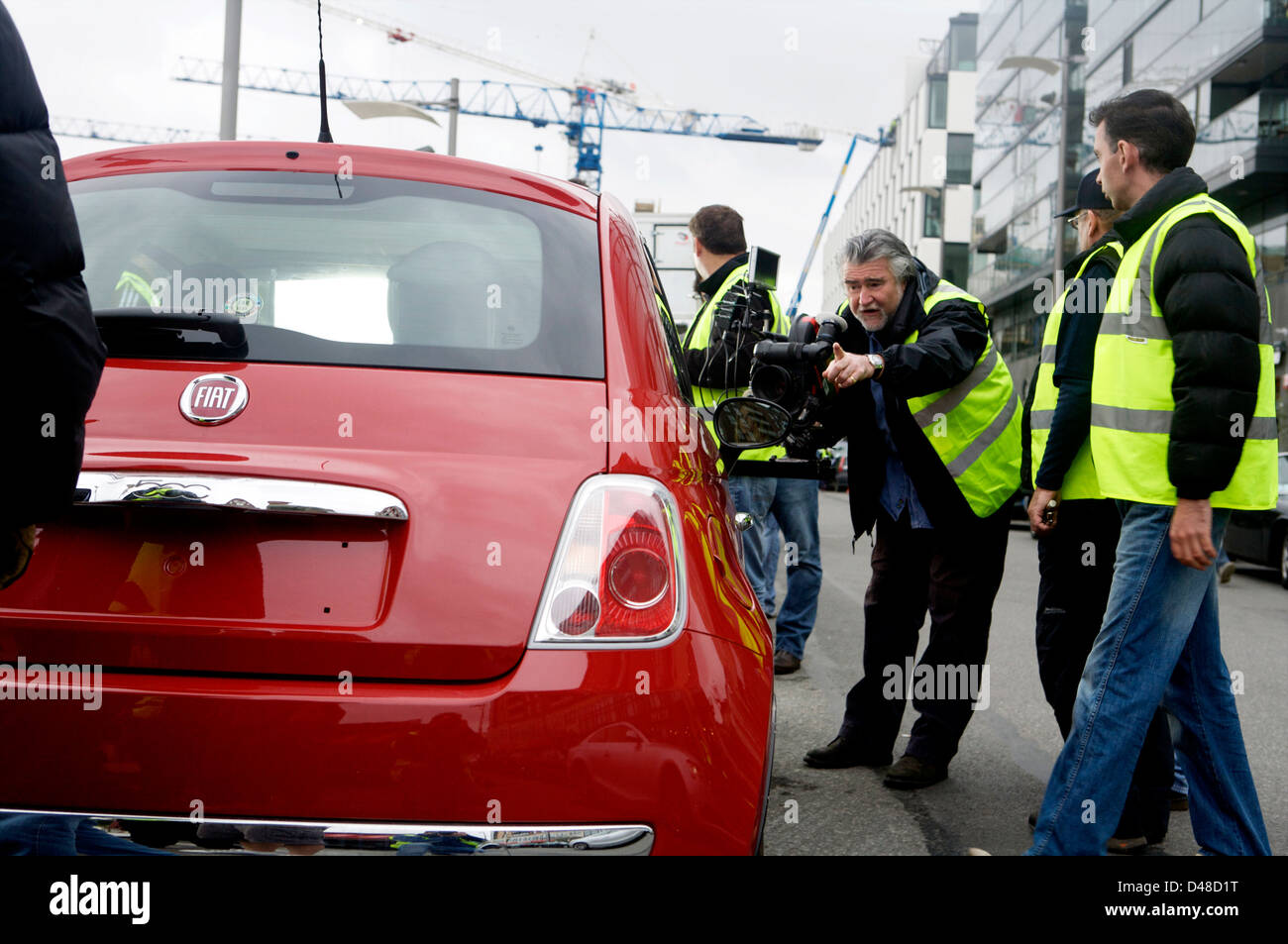 Red Fiat 500 CC with a film rig attached and crew preparing the vehicle Stock Photo