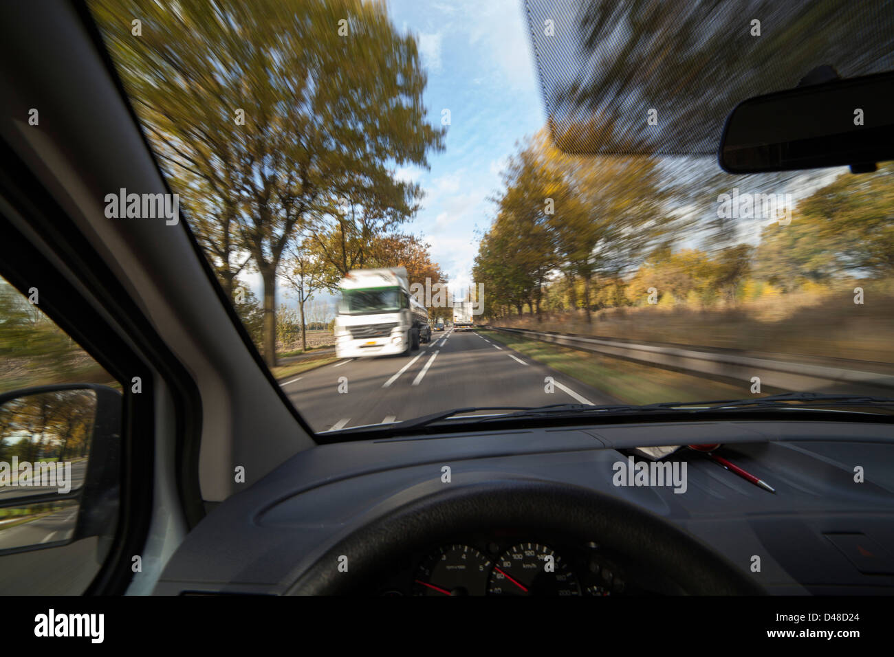 upcoming traffic from a car diver's point of view with a fast driving truck coming up Stock Photo