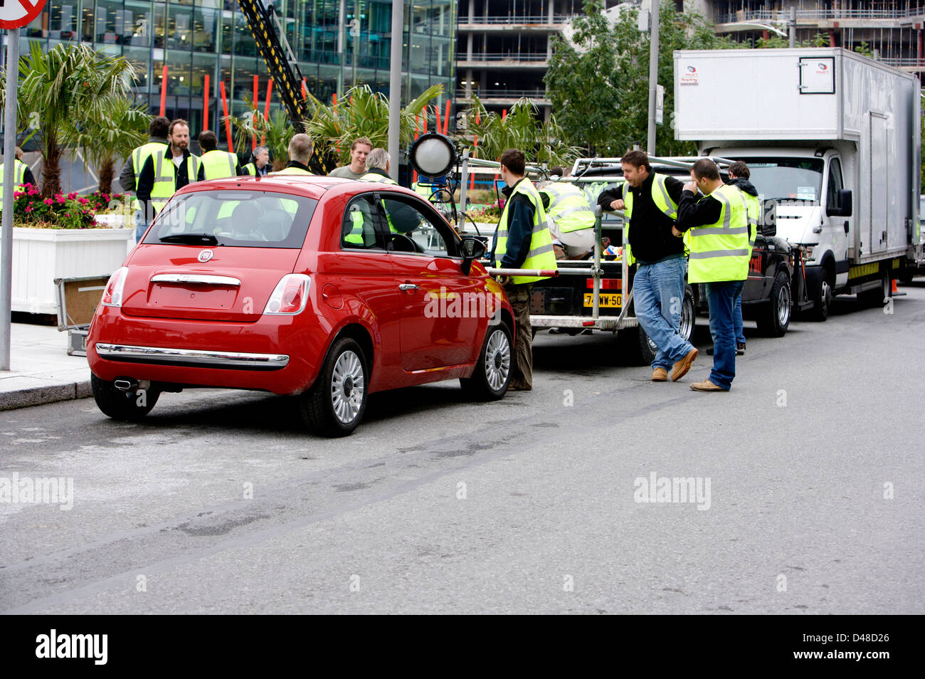 Red Fiat 500 CC with a film rig attached and crew preparing the vehicle Stock Photo