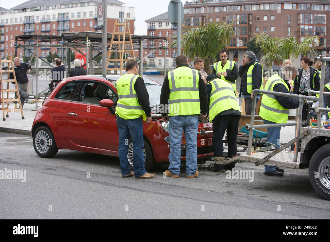 Red Fiat 500 CC with a film rig attached and crew preparing the vehicle Stock Photo