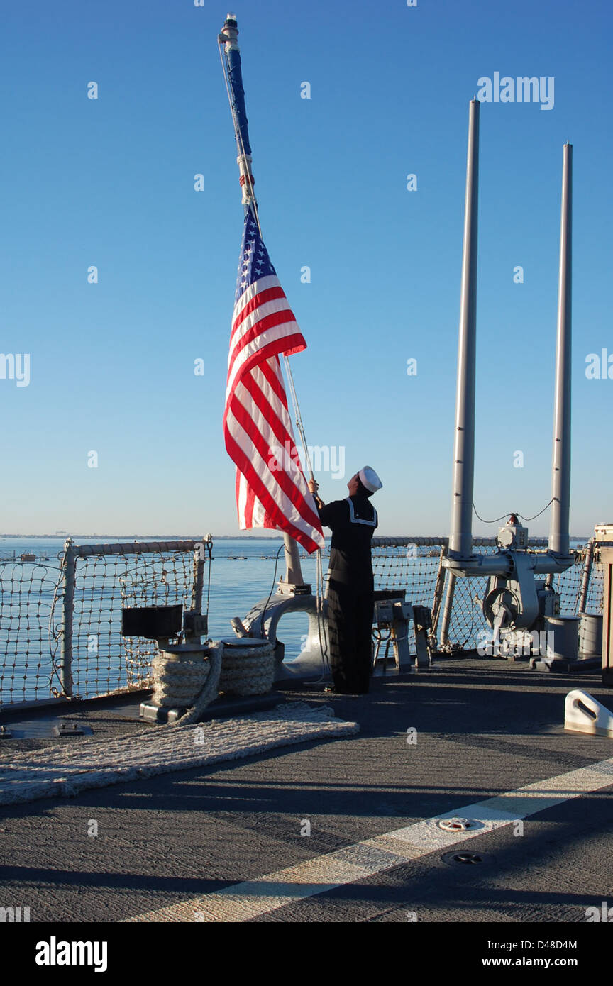 A Sailor lowers the flag to halfmast Stock Photo Alamy
