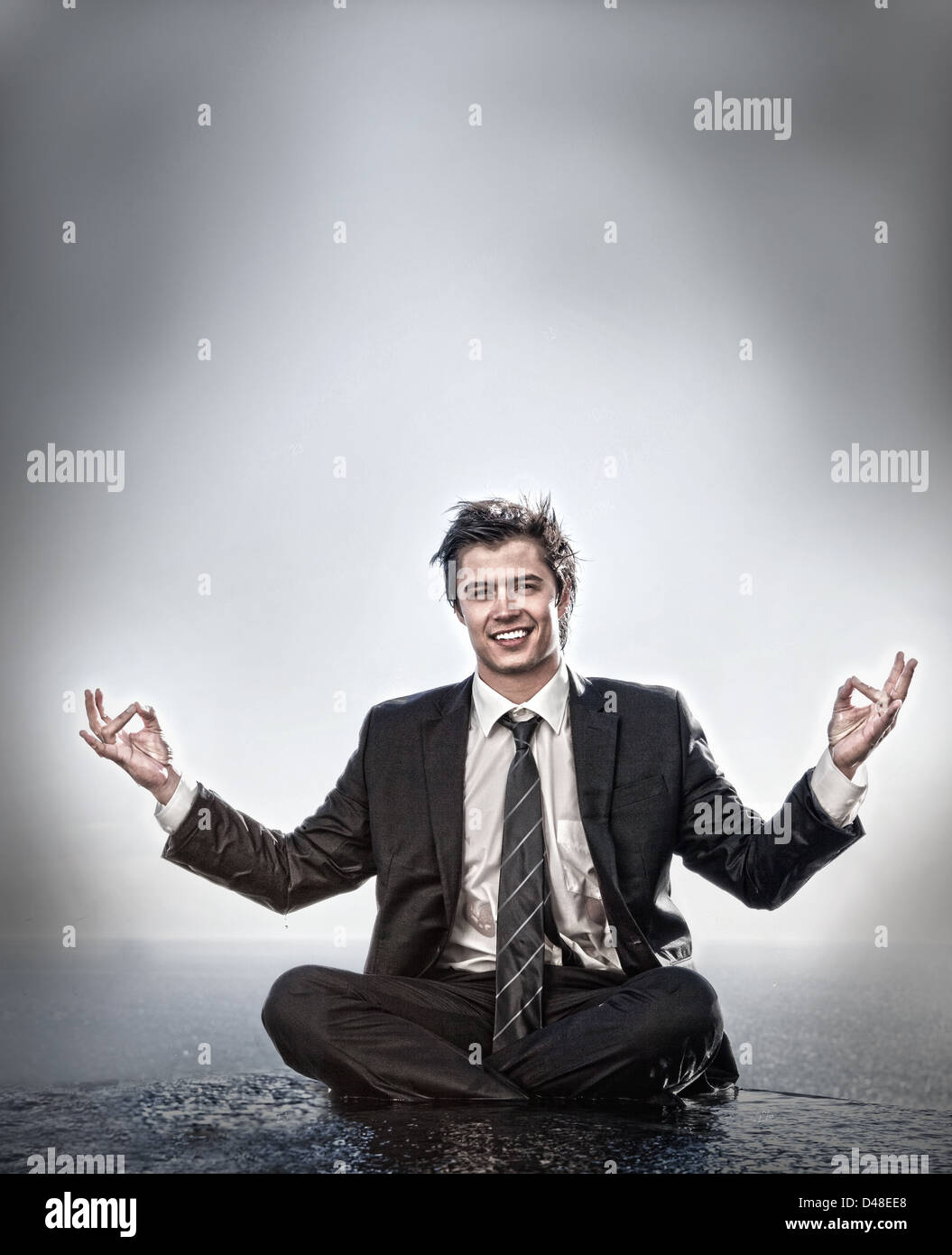 Businessman meditating and smiling Stock Photo - Alamy