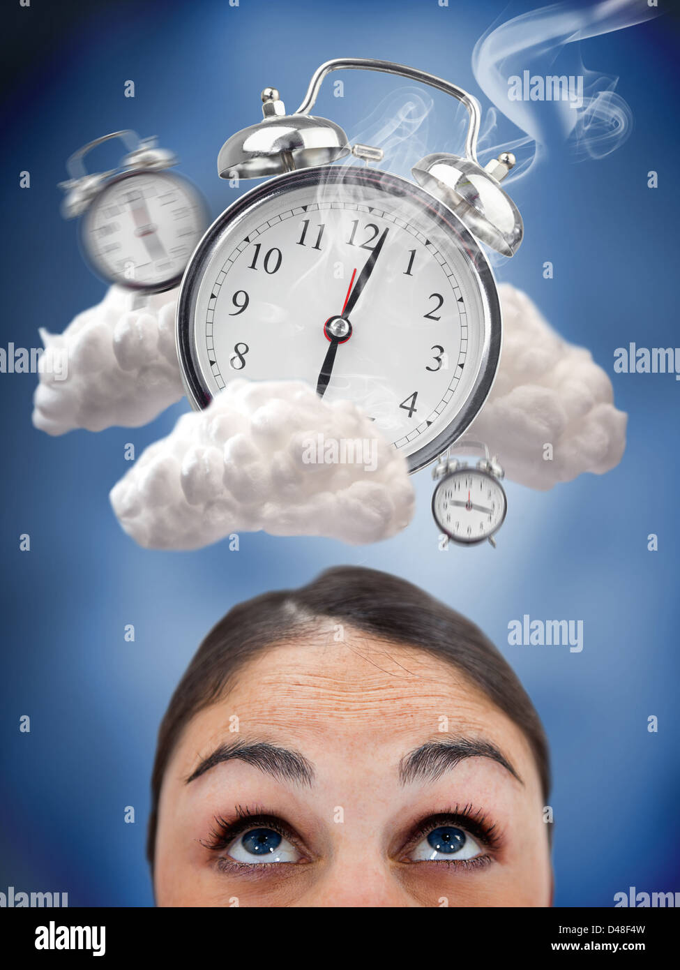 Woman looking up at ringing alarm clocks in clouds Stock Photo Alamy