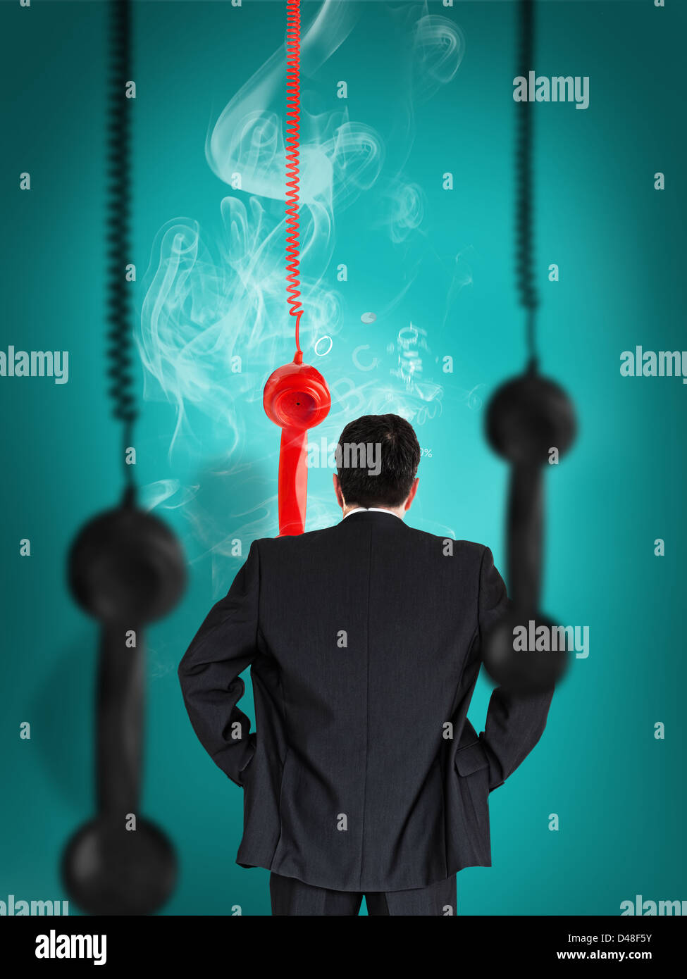 Businessman looking at smoking telephone receiver Stock Photo