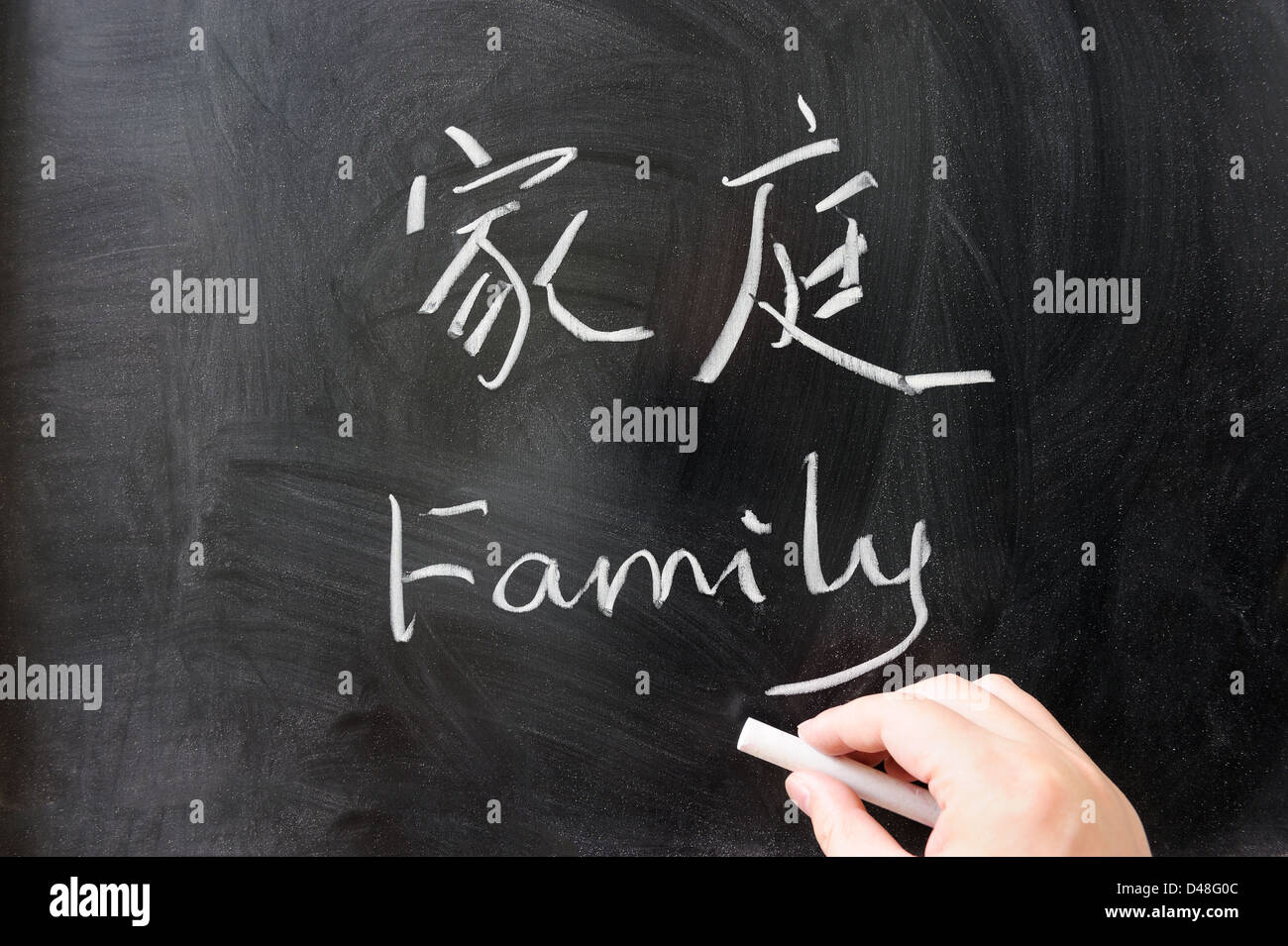 Family word in Chinese and English written on the chalkboard Stock Photo