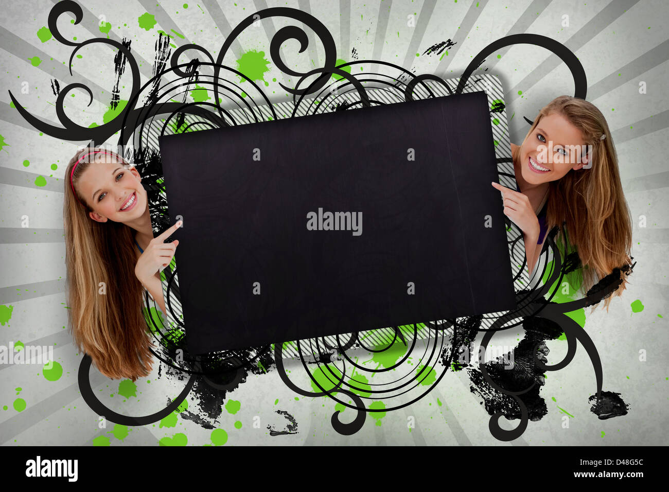 Girls pointing to black copy space with artistic black swirls Stock Photo