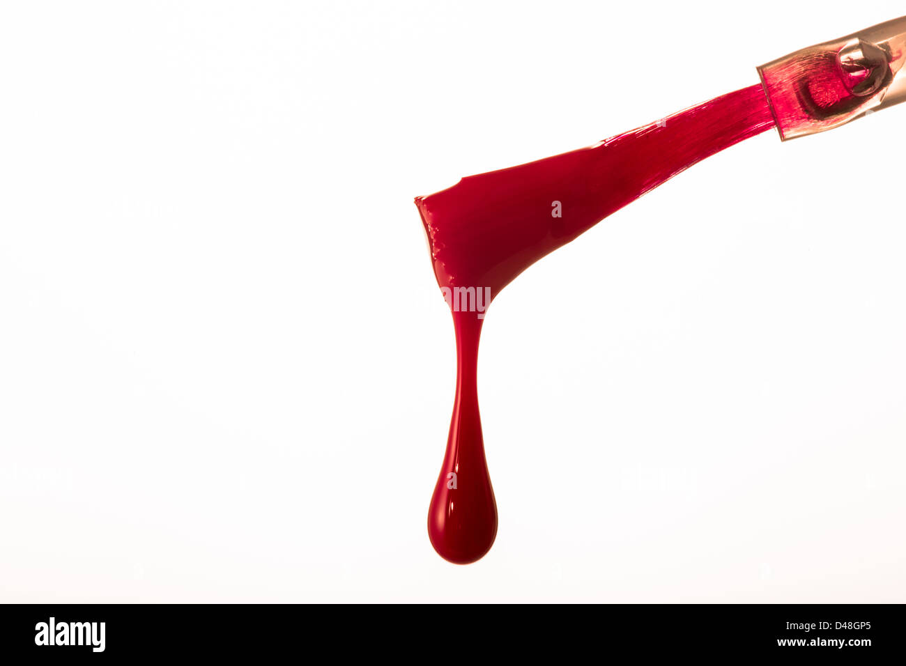 Red nail polish brush with drip Stock Photo
