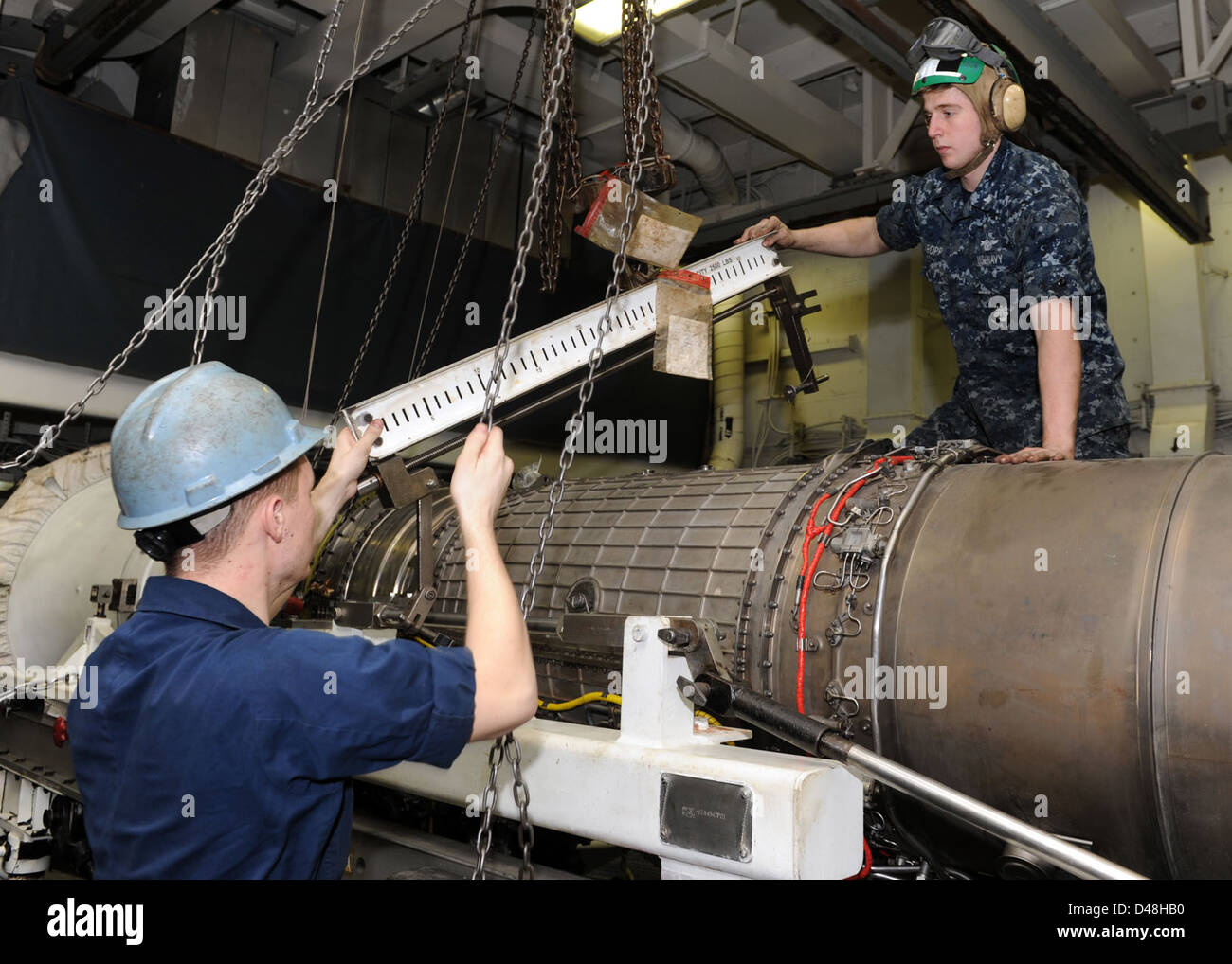Sailors secure an engine aboard a naval vessel in the U.S. 5th Fleet ...