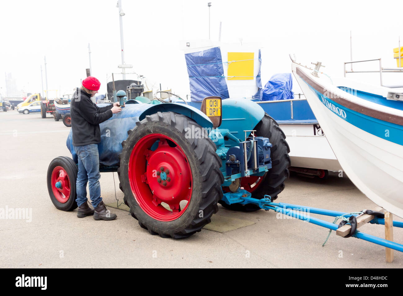 Man repairing a tractor on the new hard standing area on the rebuilt promenade and sea wall at Redcar Cleveland UK Stock Photo