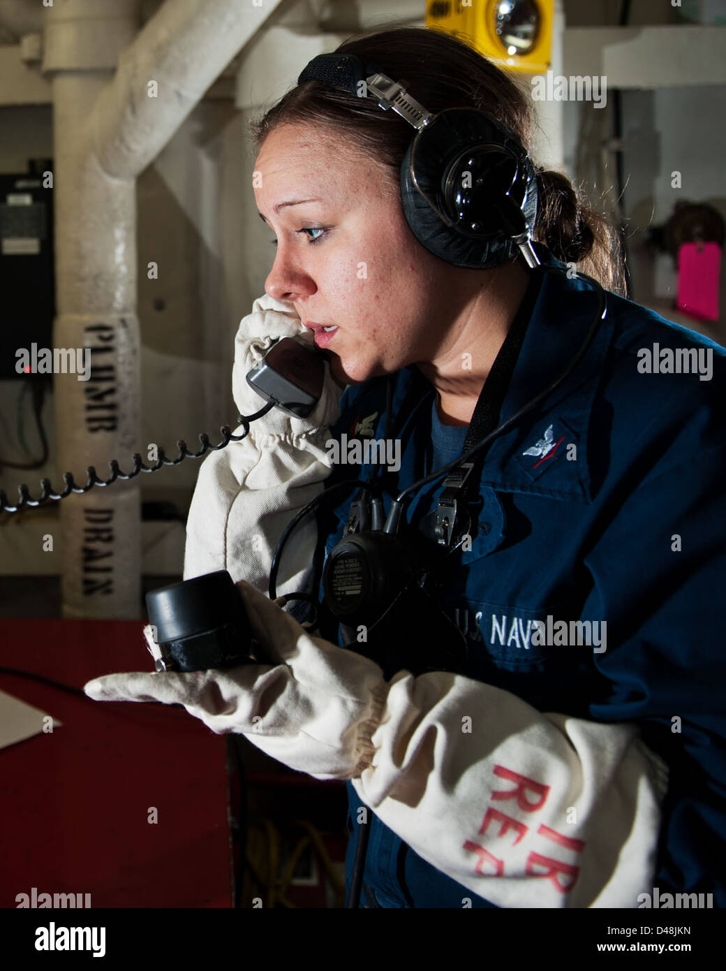A Sailor relays messages during a fire drill at sea. Stock Photo