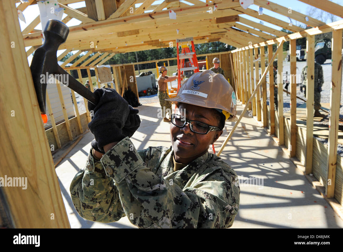 A Seabee removes nails as a hut is taken down. Stock Photo