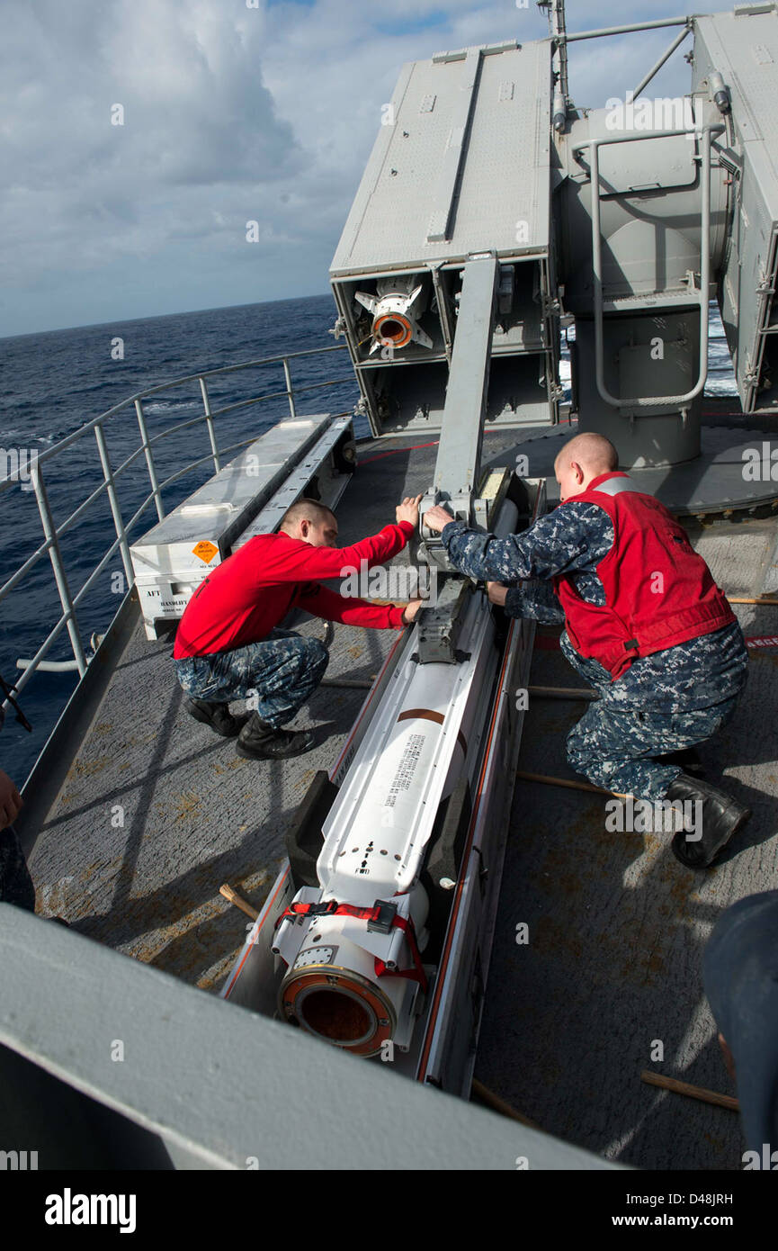 Sailors load a NATO Sea Sparrow missile at sea. Stock Photo