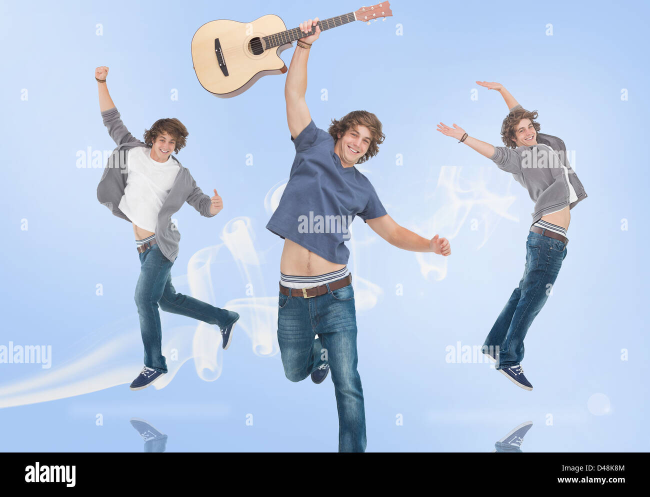 Three of the same teenage boy jumping for joy one holding a guitar Stock Photo