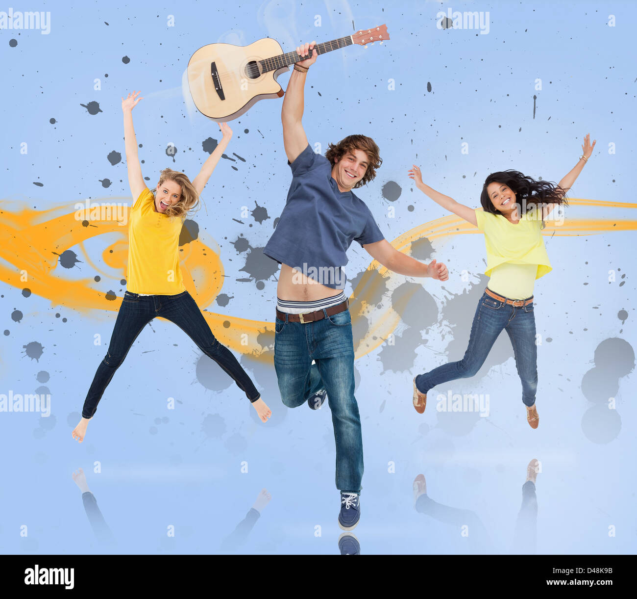Young man with guitar and two girls jumping for joy Stock Photo