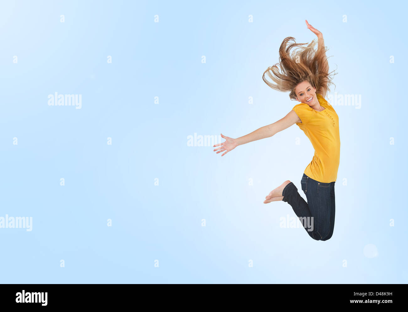 Pretty young woman jumping for joy Stock Photo