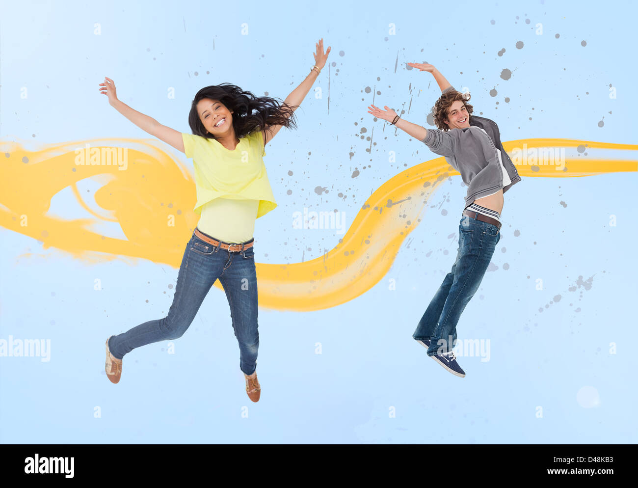 Attractive young man and woman jumping for joy Stock Photo