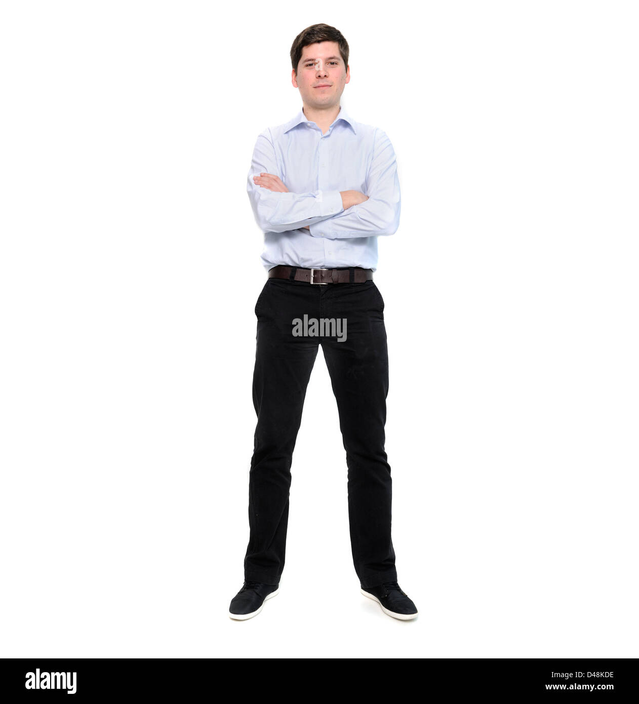 Full length portrait of young man with arms crossed isolated on white background Stock Photo