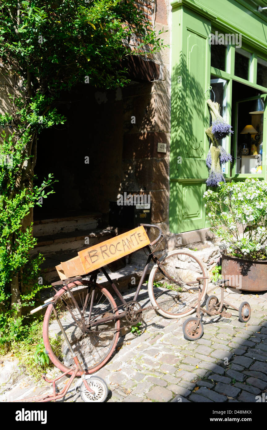 Old bicycle outside M. Terruel's brocante shop selling bric-a-brac and antiques. Cordes, Tarn, France Stock Photo