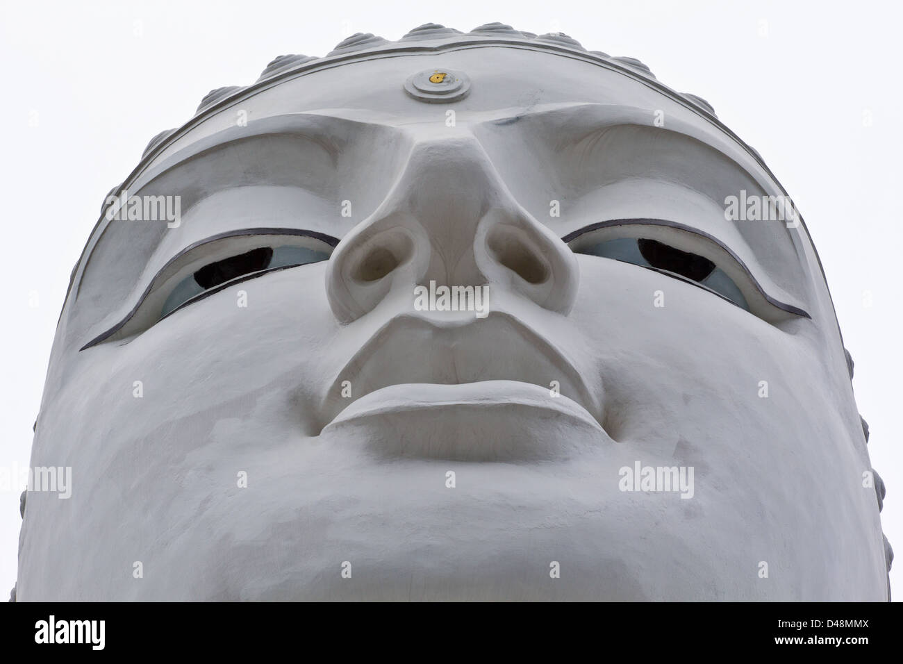 THE FACE OF A LARGE WHITE BUDDHA STATUE ON A HILL WHICH OVERLOOKS KANDY IN SRI LANKA Stock Photo