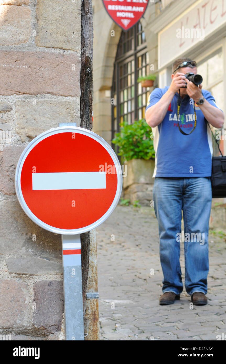 Photographer on holiday by a no entry road sign. Cordes, Tarn, France Stock Photo