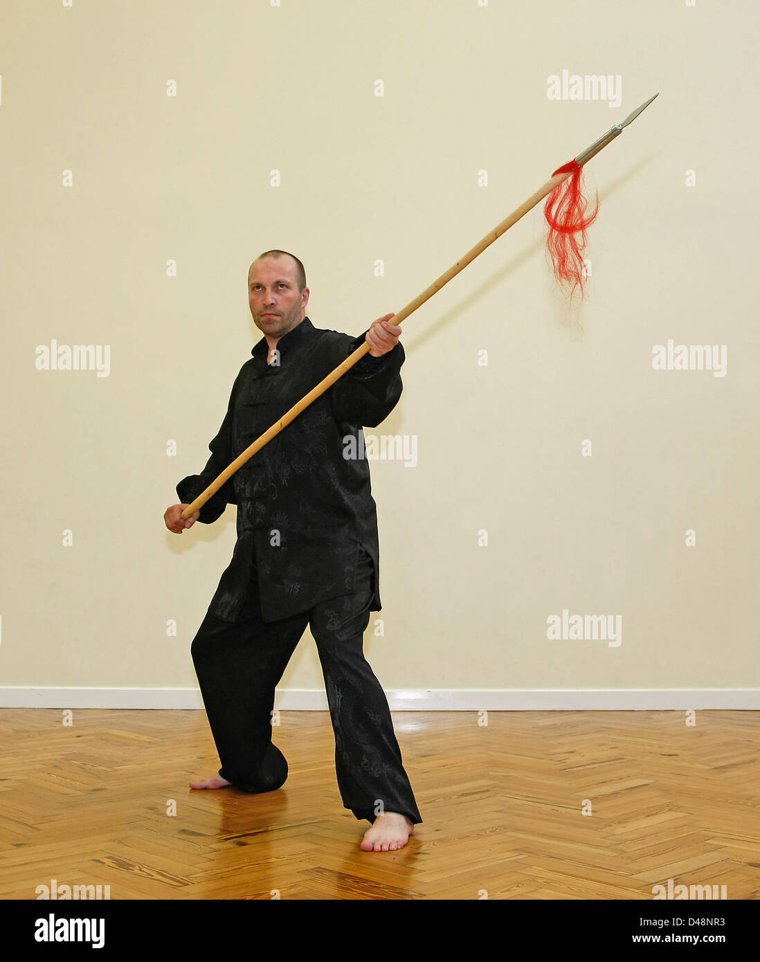Man posing in a martial arts stance with a ceremonial spear Stock Photo Alamy