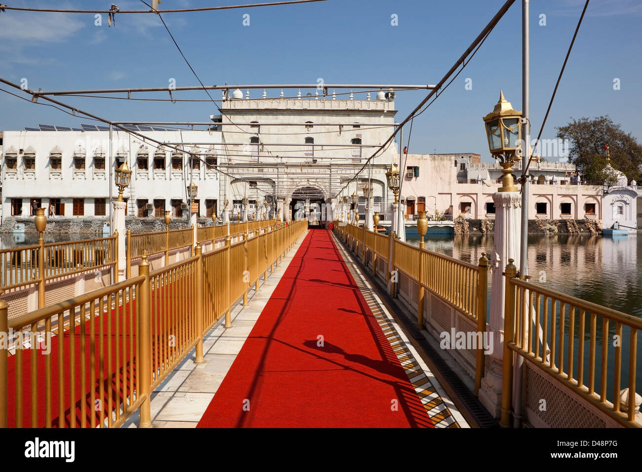 Red carpet and gold railings at the entrance walkway to the Shree Durgiana Hindu temple, Amritsar, Punjab, India Stock Photo