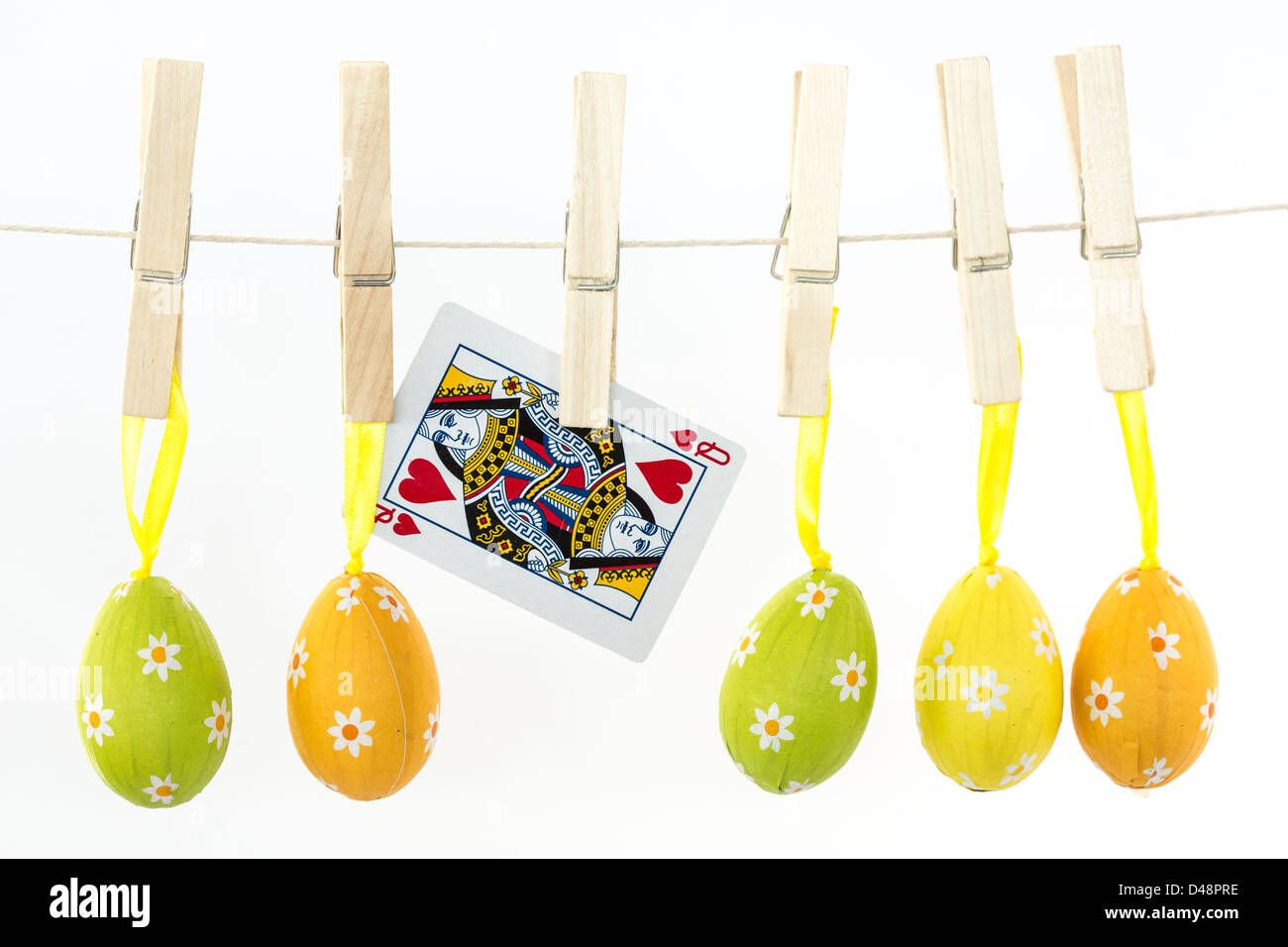 Easter eggs hanging from a line with queen of hearts Stock Photo