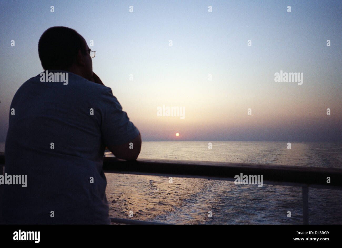 Man watching sunset on board ship Stock Photo - Alamy