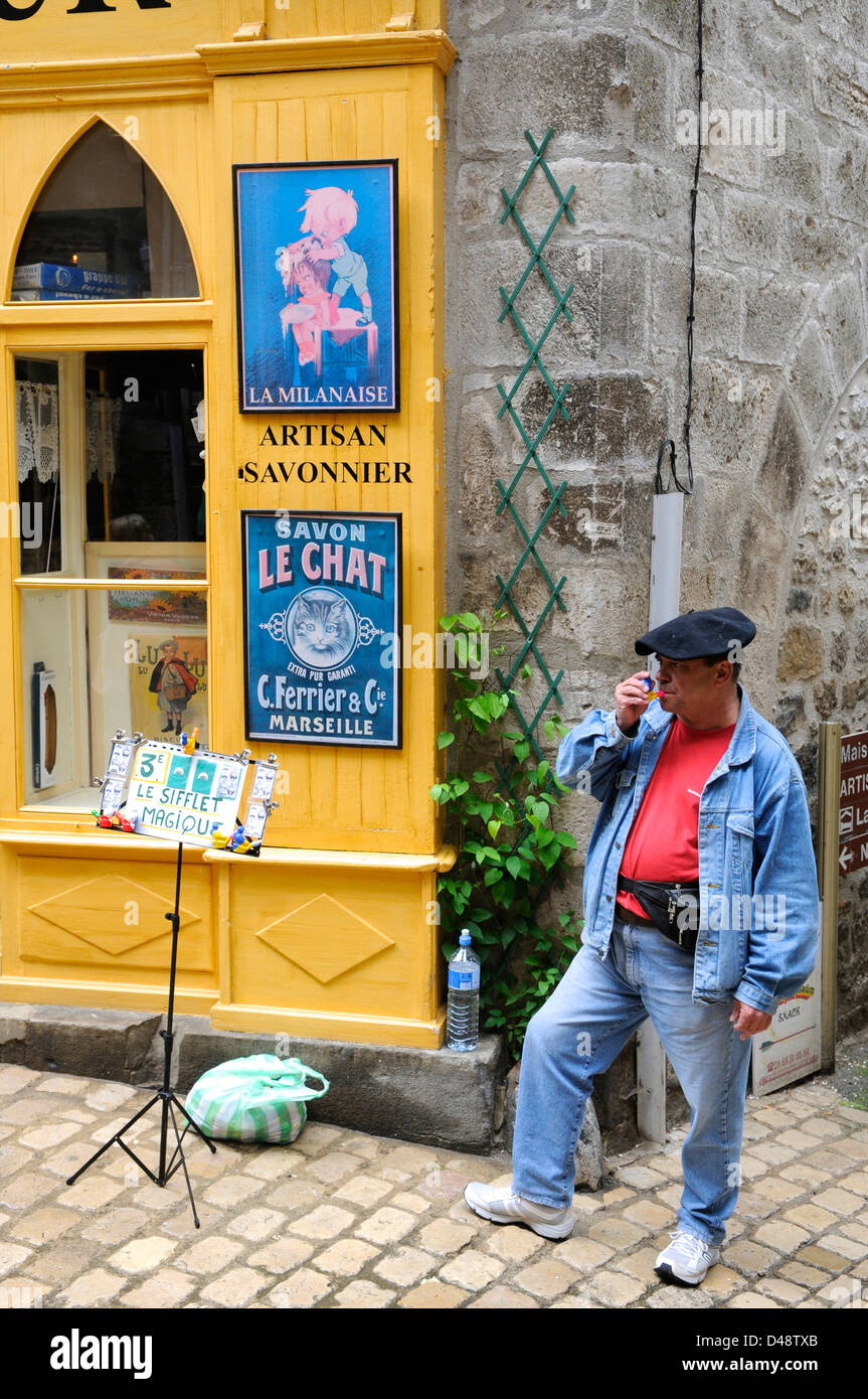 Man selling children's whistles in the market. St Antonin Noble Val, Averyron, France Stock Photo