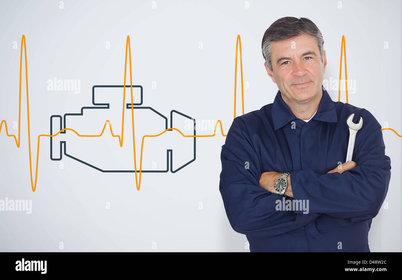 Mature mechanic standing in front of an engine background Stock Photo