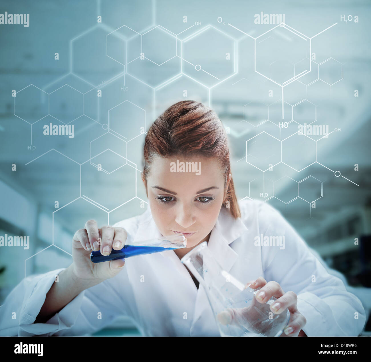 Scientist pouring liquid into erlenmeyer with futuristic screen showing formula Stock Photo